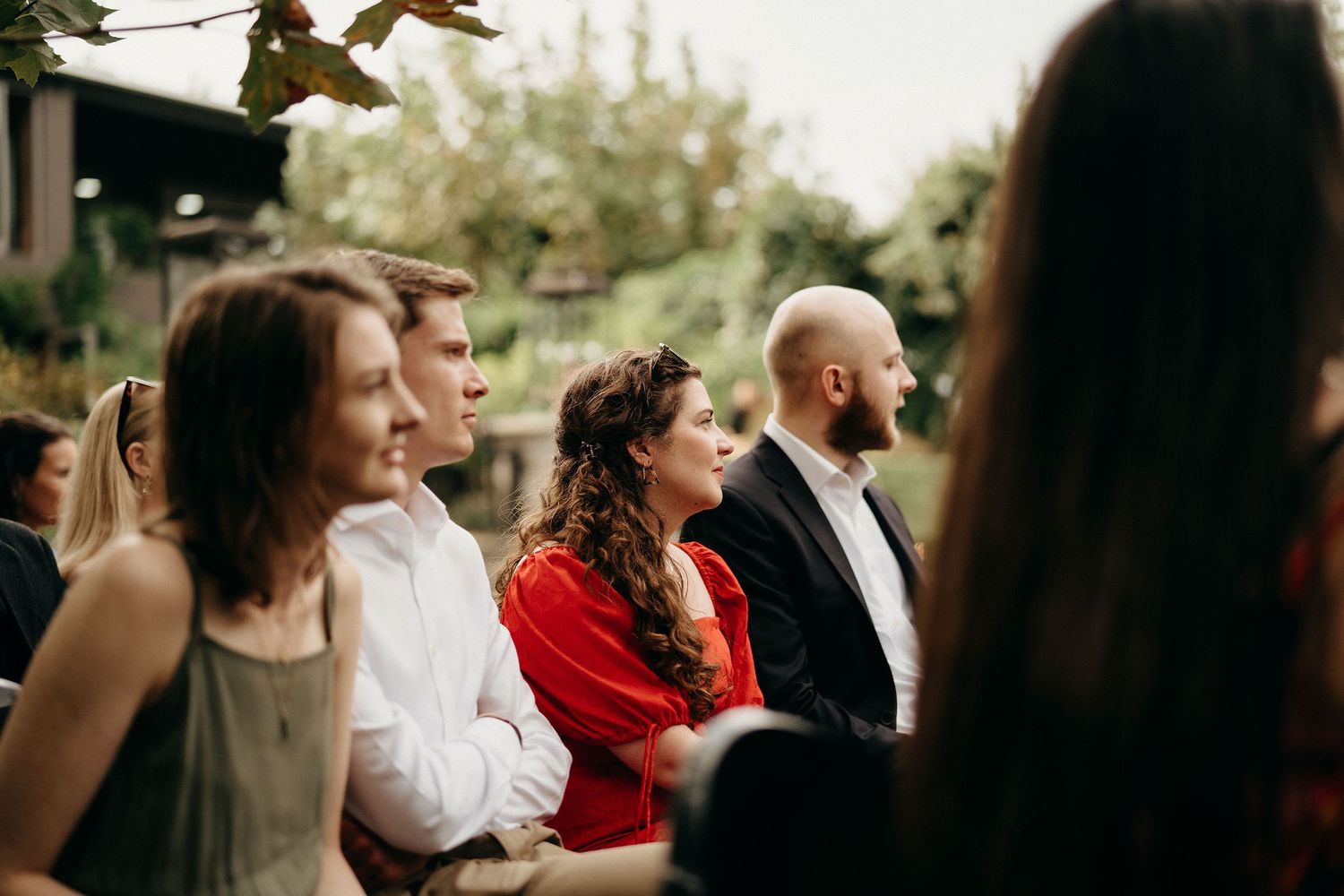 A group of attendees watching intently during an outdoor ceremony gathering.