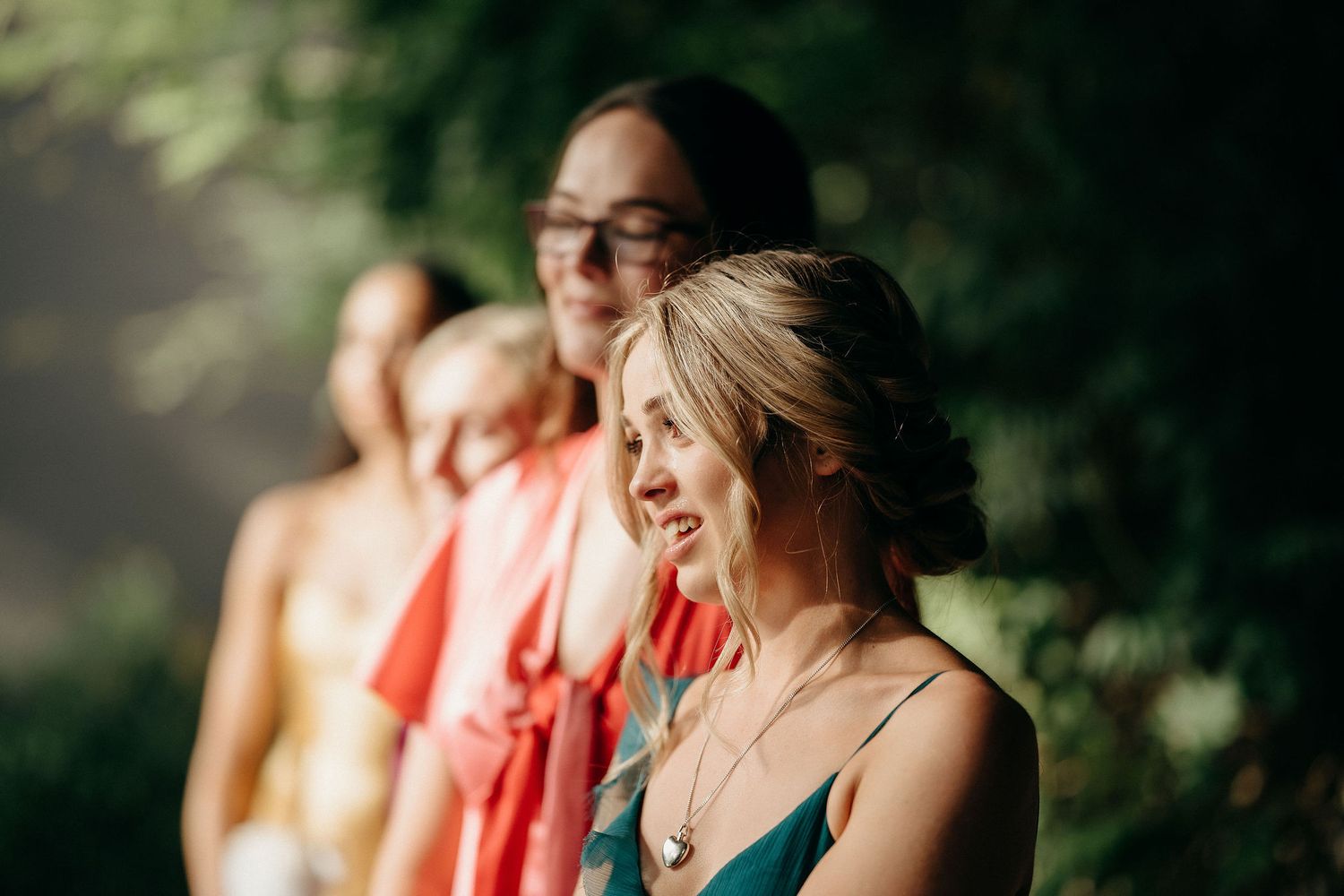 Wedding guests share laughter during an outdoor celebration in natural lighting.
