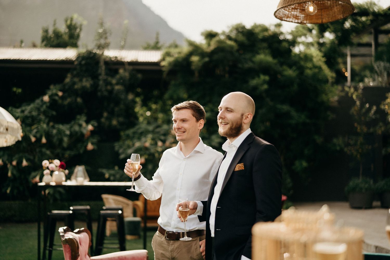 Two people sharing drinks and conversation during an outdoor celebration event on a cloudy day.