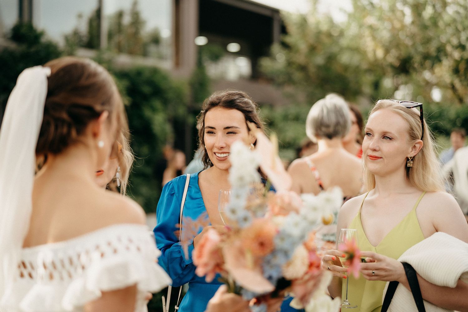 Guests enjoying refreshments at an outdoor wedding reception on a sunny summer afternoon.
