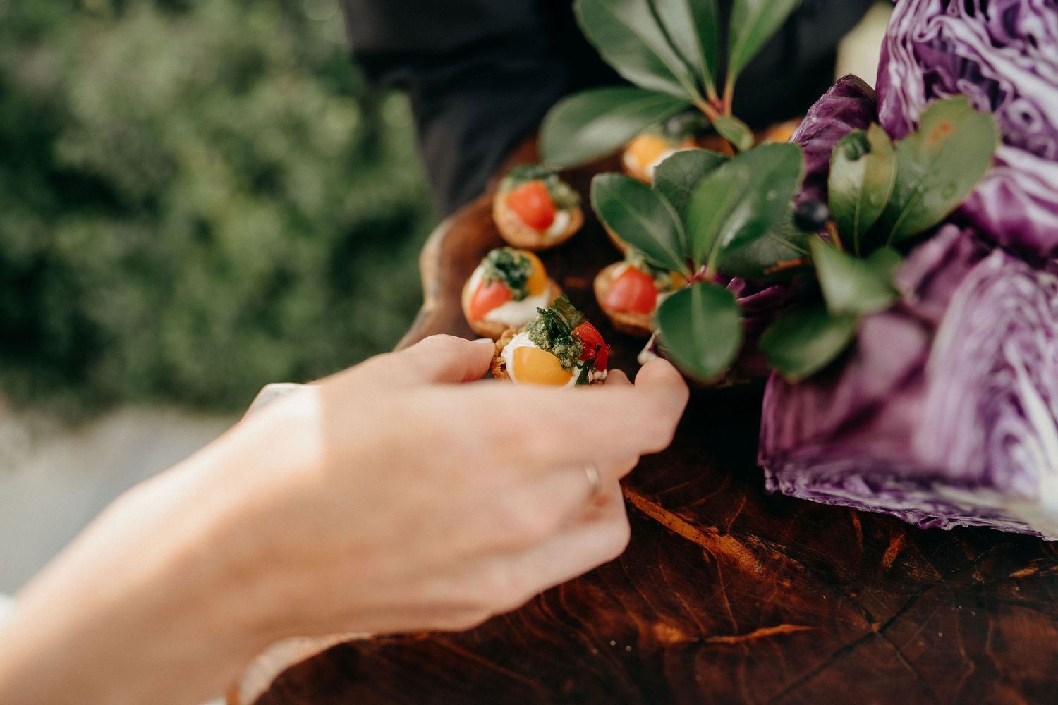 Hand holding freshly picked orange berries against a floral patterned background with soft natural lighting.