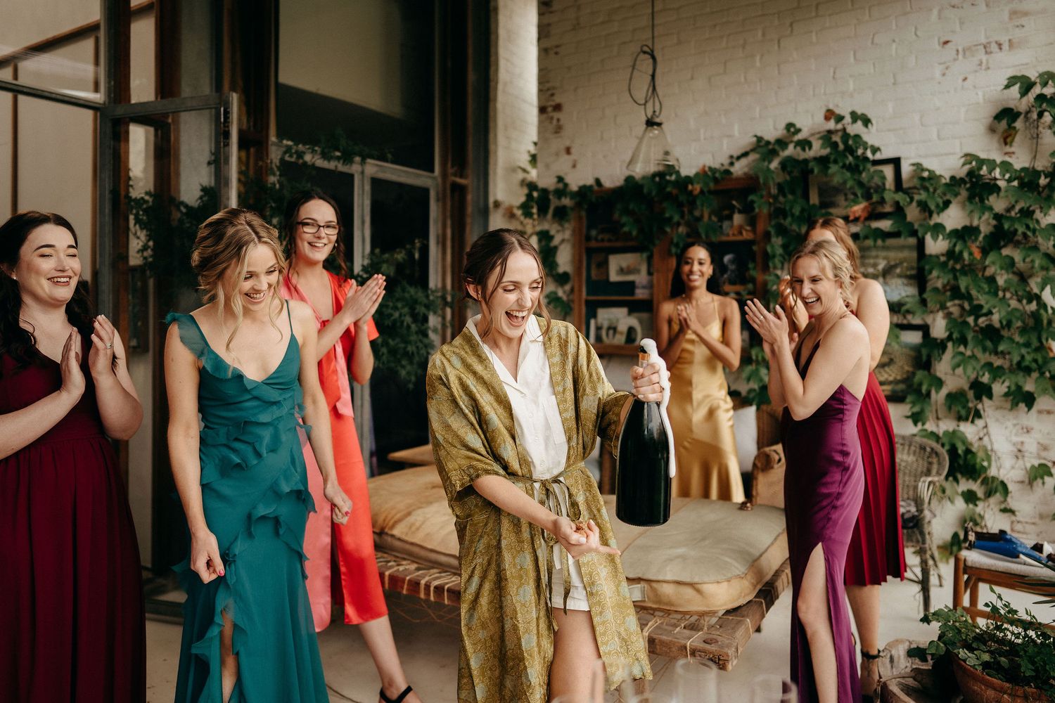 Group wearing colorful dresses and formalwear gather on outdoor patio during special event celebration.