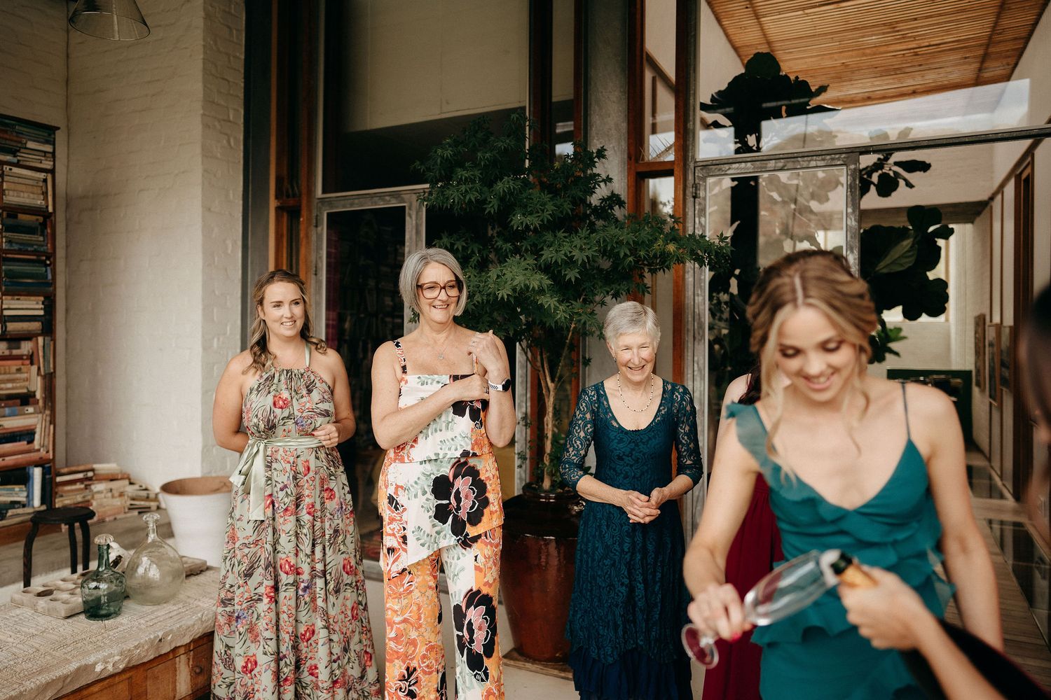 A group enjoying a celebration on a covered patio with wine glasses and festive attire.