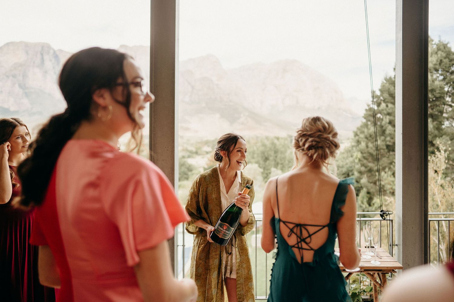 People gathered on a balcony with a scenic mountain view in the background.