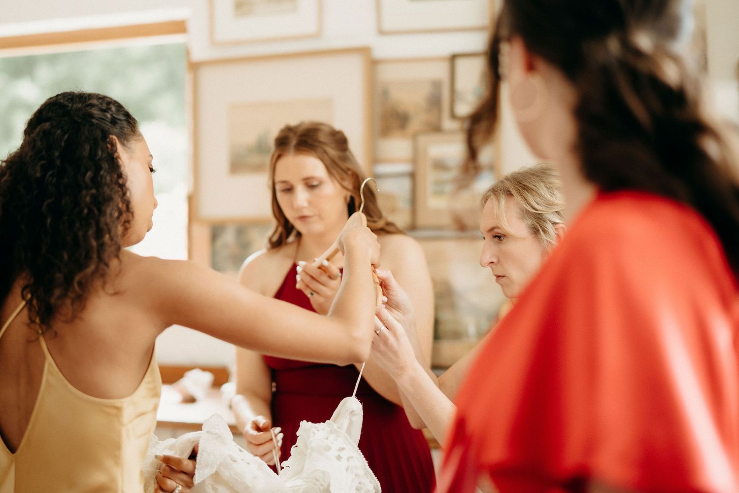 A group of people chat and smile together at a casual gathering in a bright interior space.