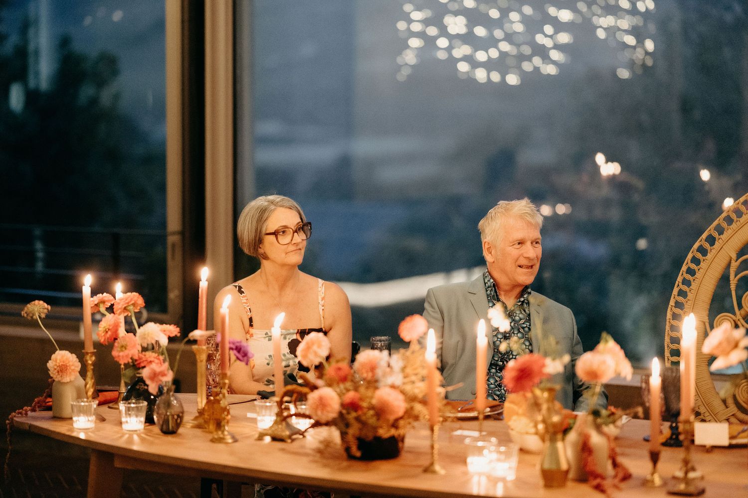 Elegant wedding reception table setting with candles and soft lighting creating romantic evening ambiance.