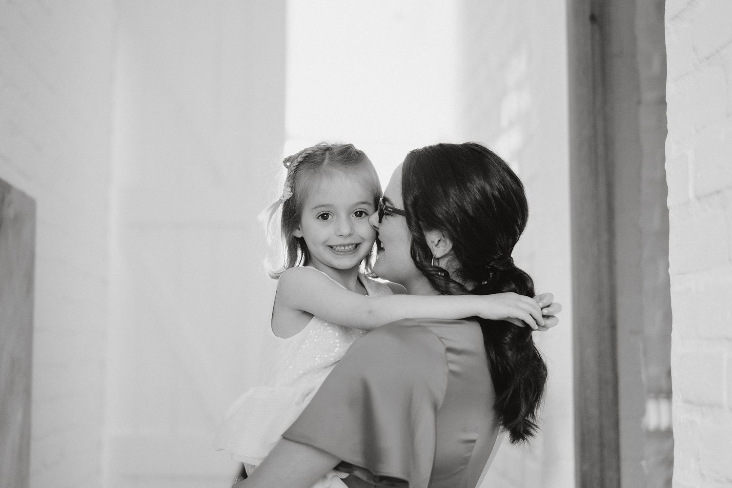 A parent and child in a heartwarming embrace share an intimate black and white moment together.