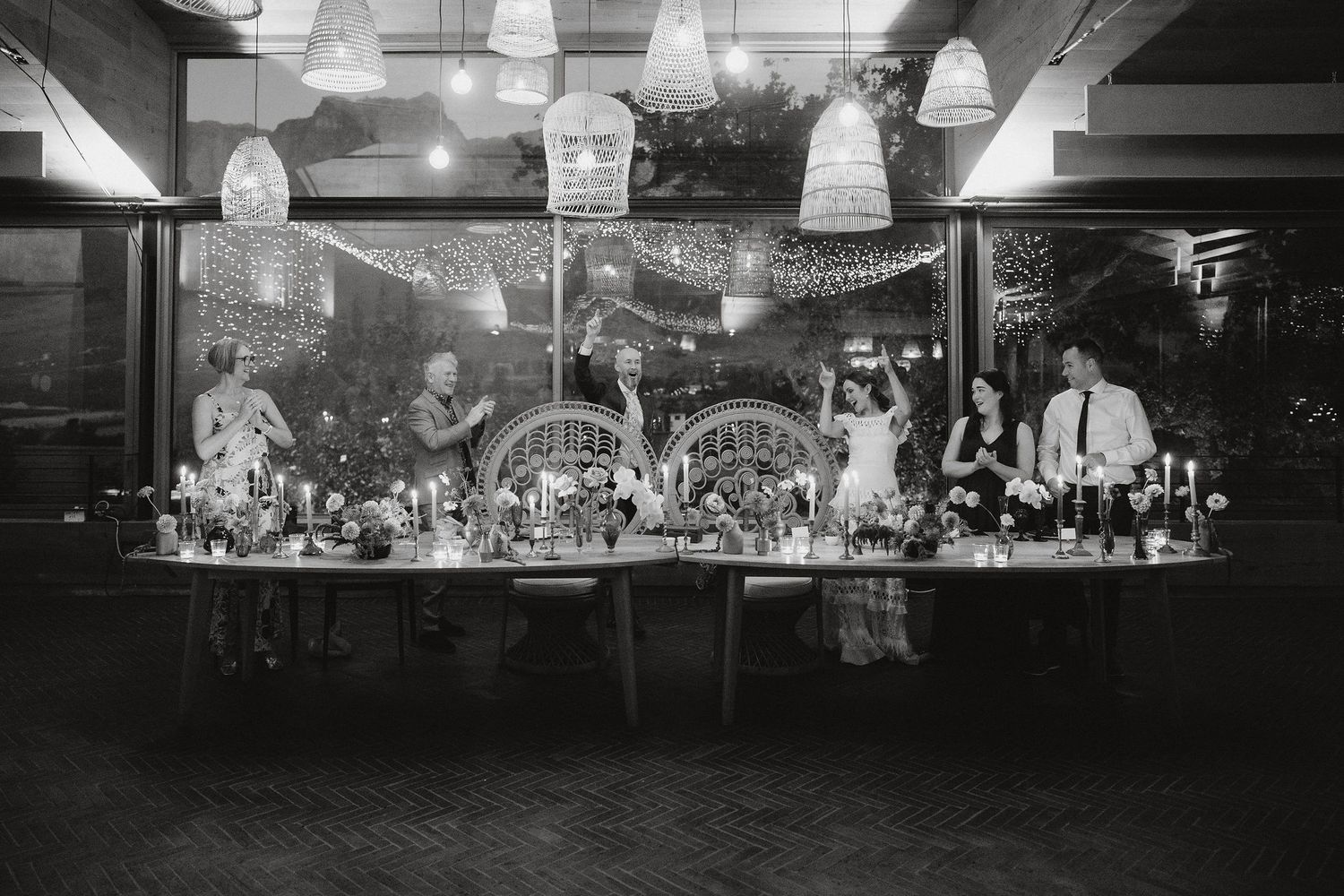 A vintage black and white photograph of an elegant bar display with hanging pendant lights and decorative glassware.