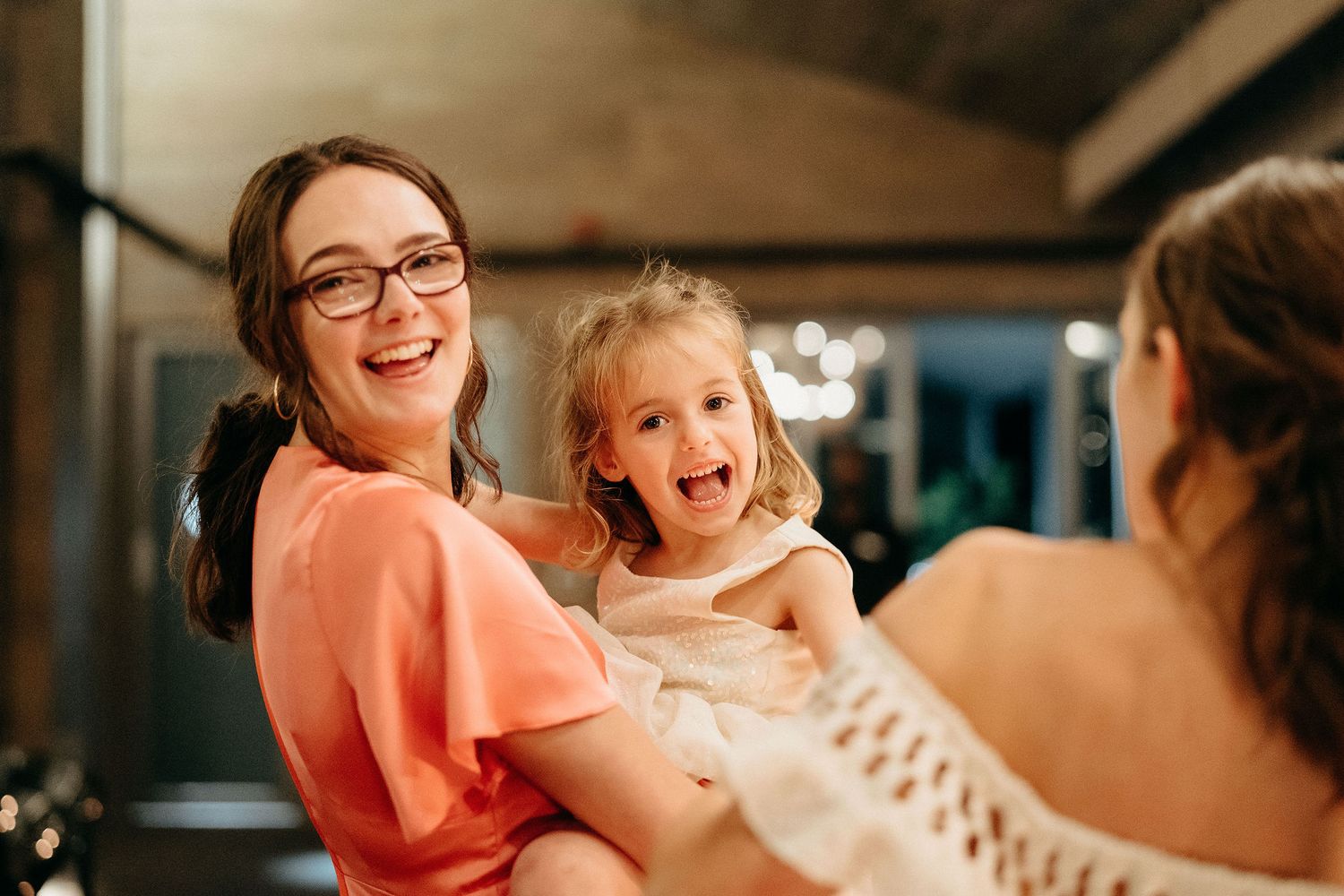 People sharing a joyful moment together indoors with warm lighting and laughter.
