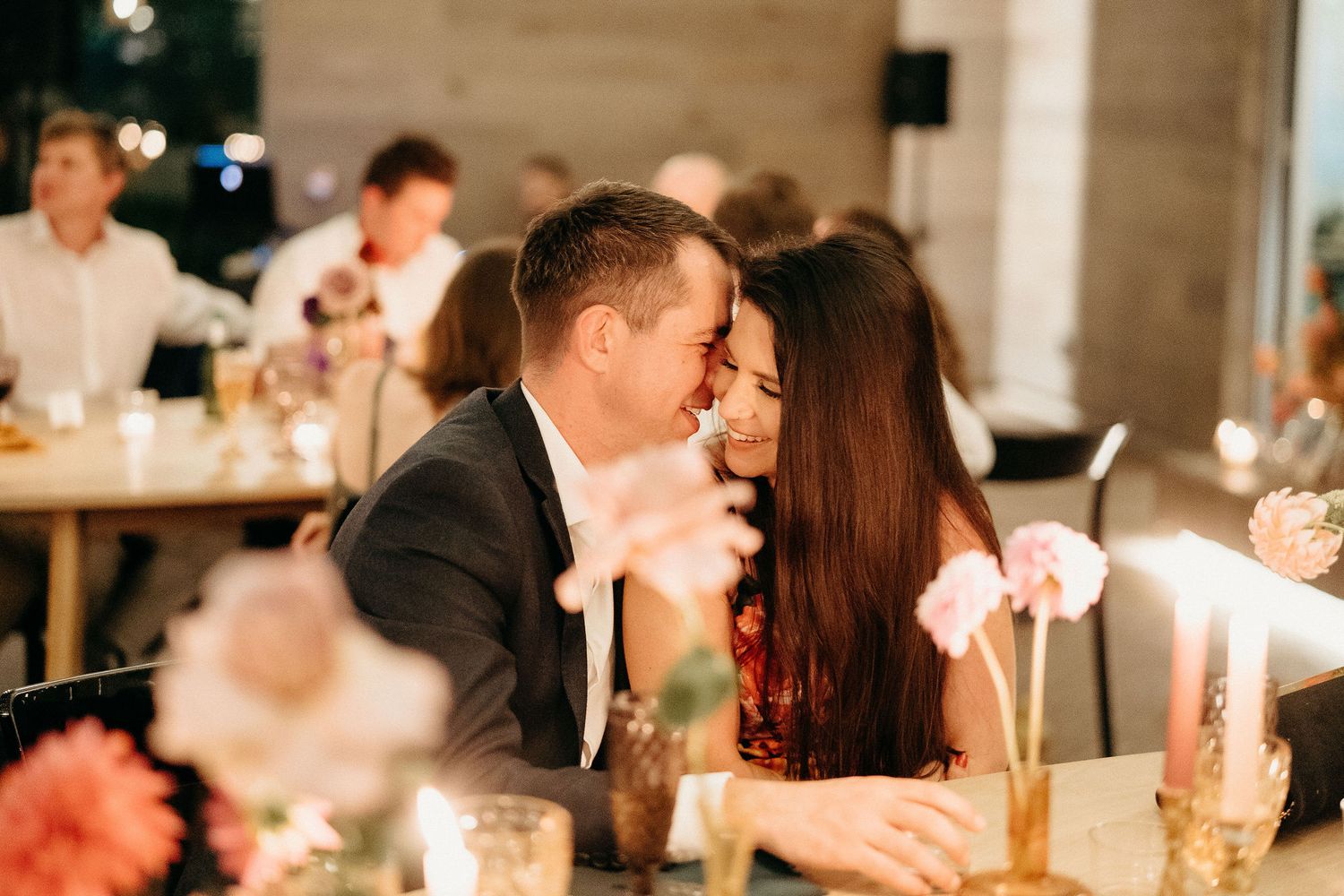 A romantic candlelit dinner scene with soft lighting and floral decorations on the table at an intimate restaurant setting.