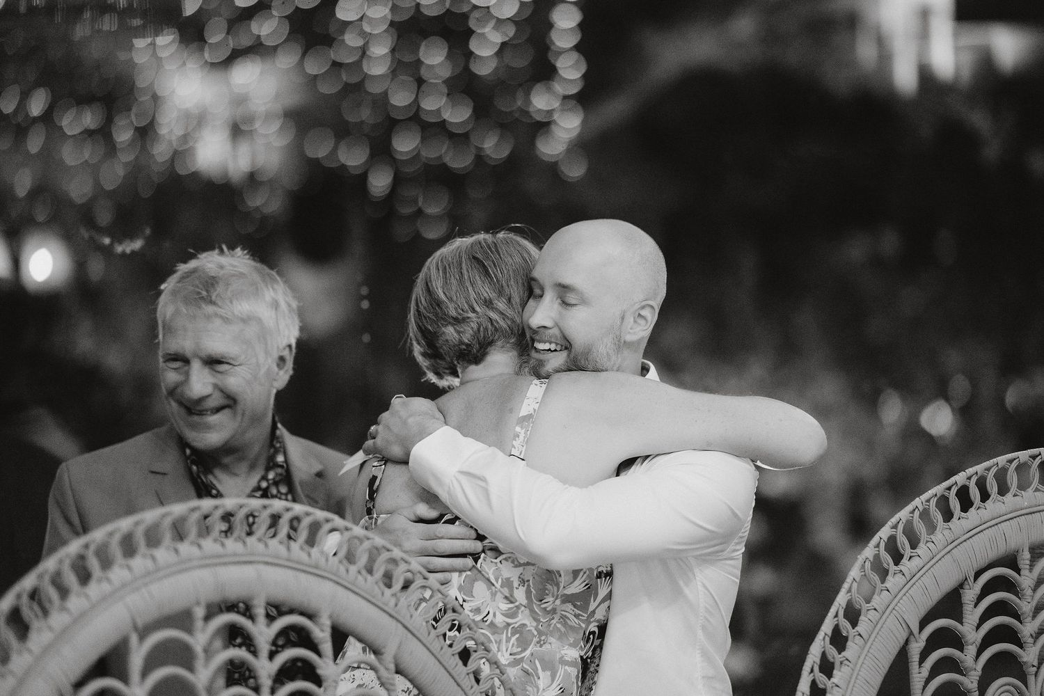 Beautiful black and white wedding moment captured at a decorative metal rail venue with guests reacting emotionally.