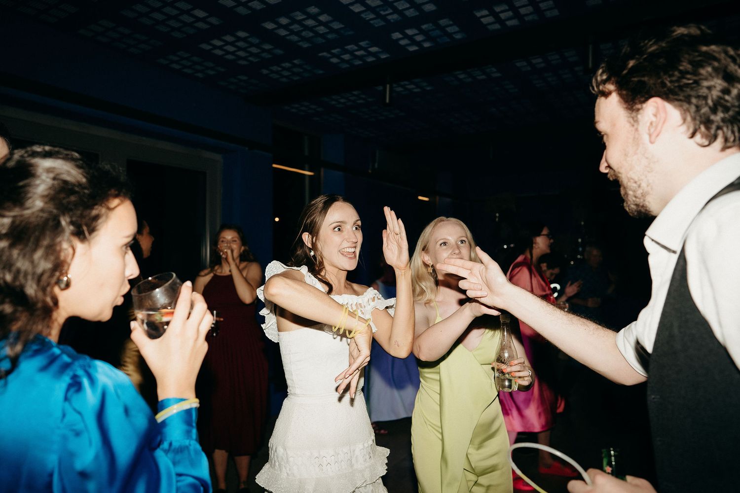 People dancing and celebrating at a wedding reception with festive energy on the dance floor.