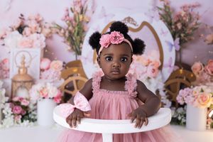 A pink and floral themed photoshoot setup with delicate flowers and decorative elements in soft pastel tones.