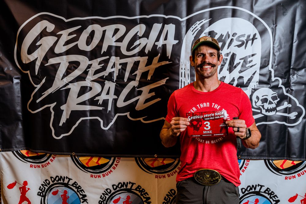 Runner standing in front of black Georgia Death Race event backdrop.