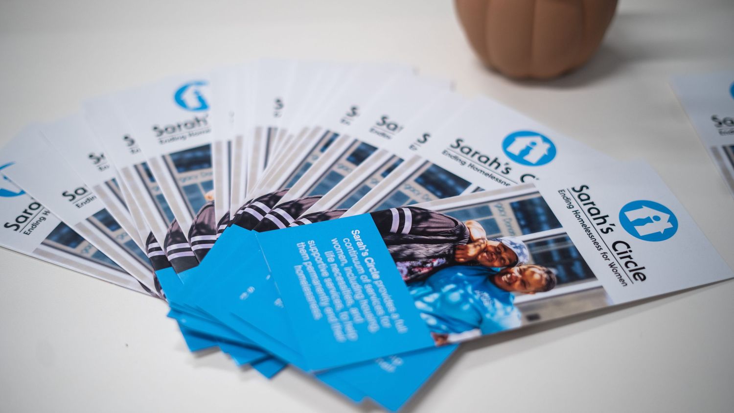 Marketing business cards fanned out on a white surface showing blue and white designs in selective focus.
