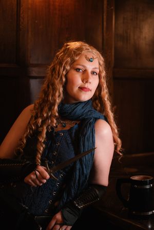 Artistic fantasy portrait series featuring vintage-inspired styling with red curly hair and navy blue clothing in a dark setting.