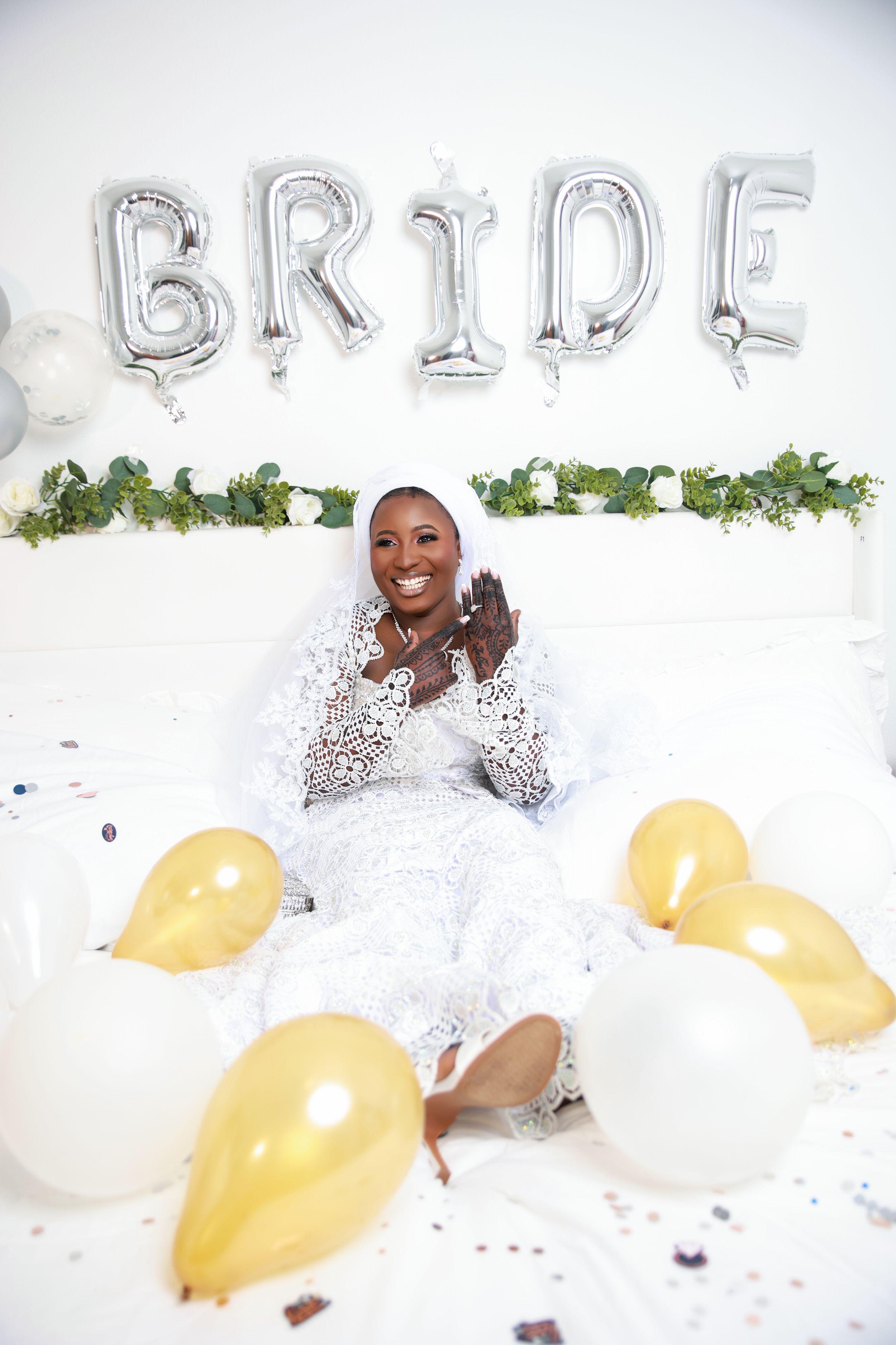 Bridal photoshoot with silver letter balloons, yellow balloons, and white decor elements.