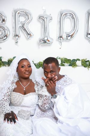 Wedding couple shares intimate moments during photo shoot with silver letter decorations.