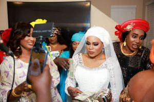 Women in traditional African dress and headwraps enjoying a festive celebration.