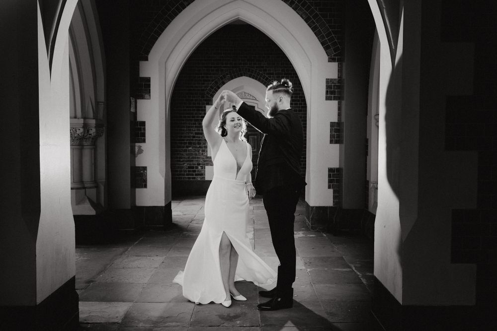 A bride and groom dance beneath an archway, captured by Apertured Media Auckland Wedding Photographer.