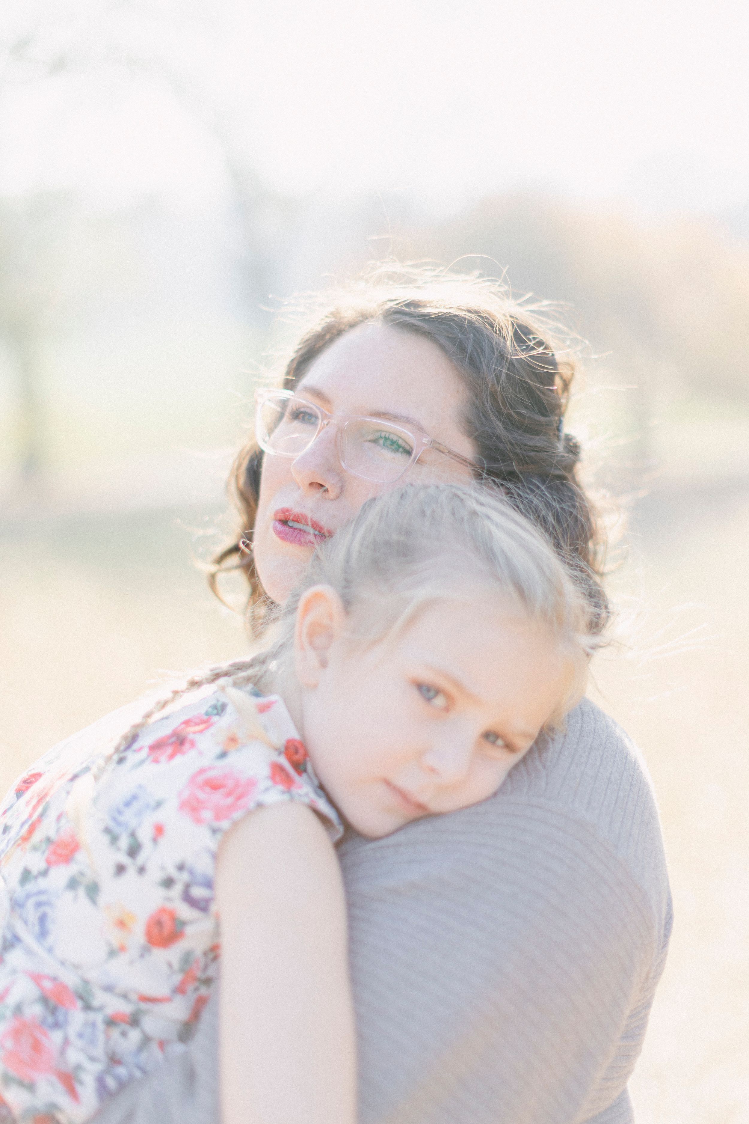 Two people share a tender embrace in dreamy natural light.
