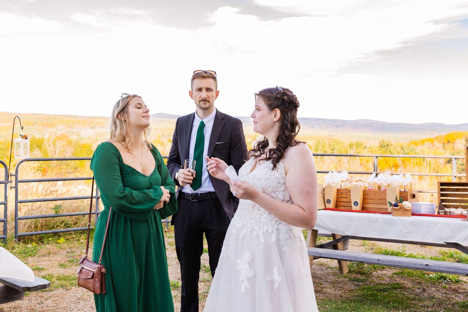 Outdoor celebration with people conversing against backdrop of autumn mountains.