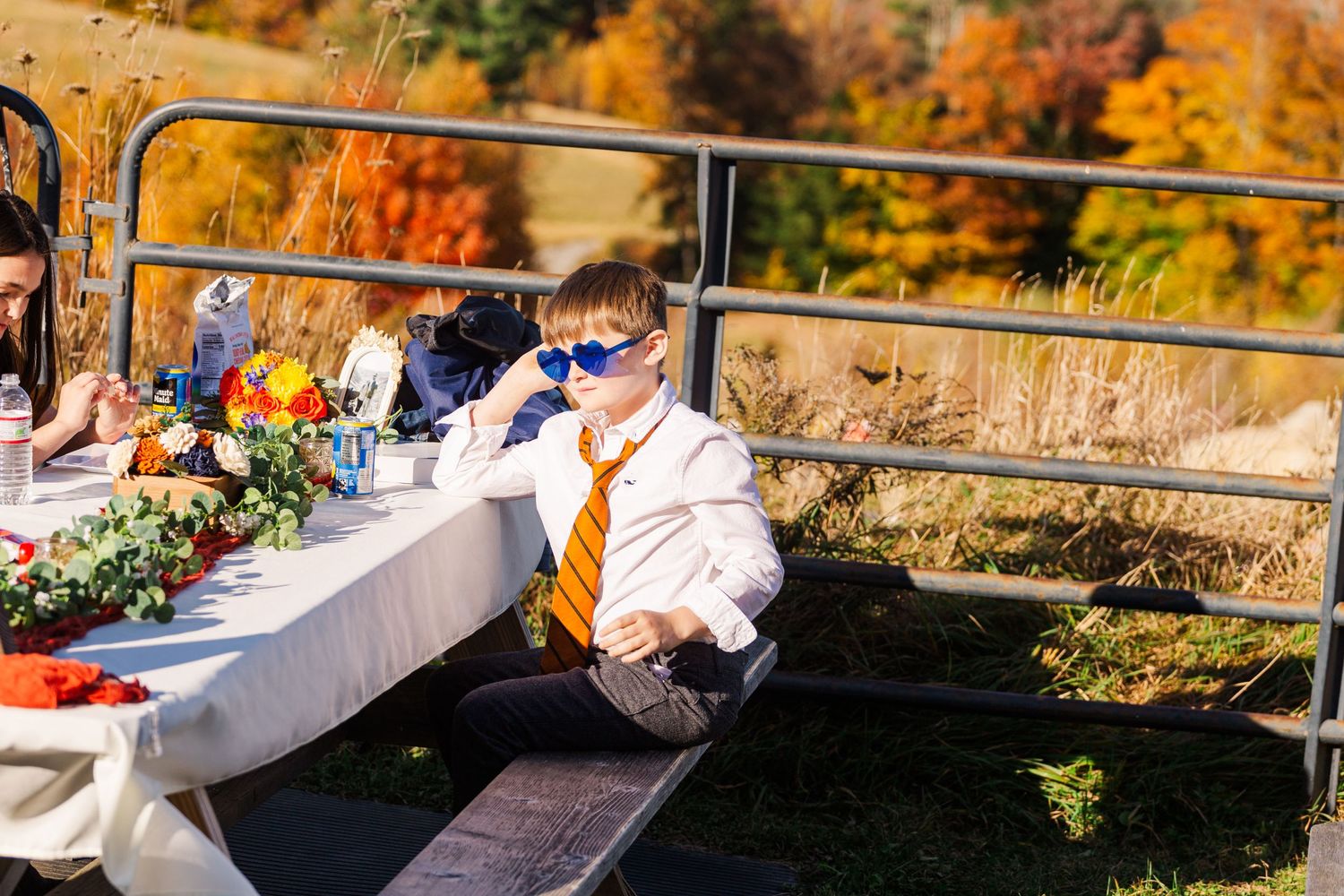 Outdoor autumn gathering with dining setup and mountains in background.