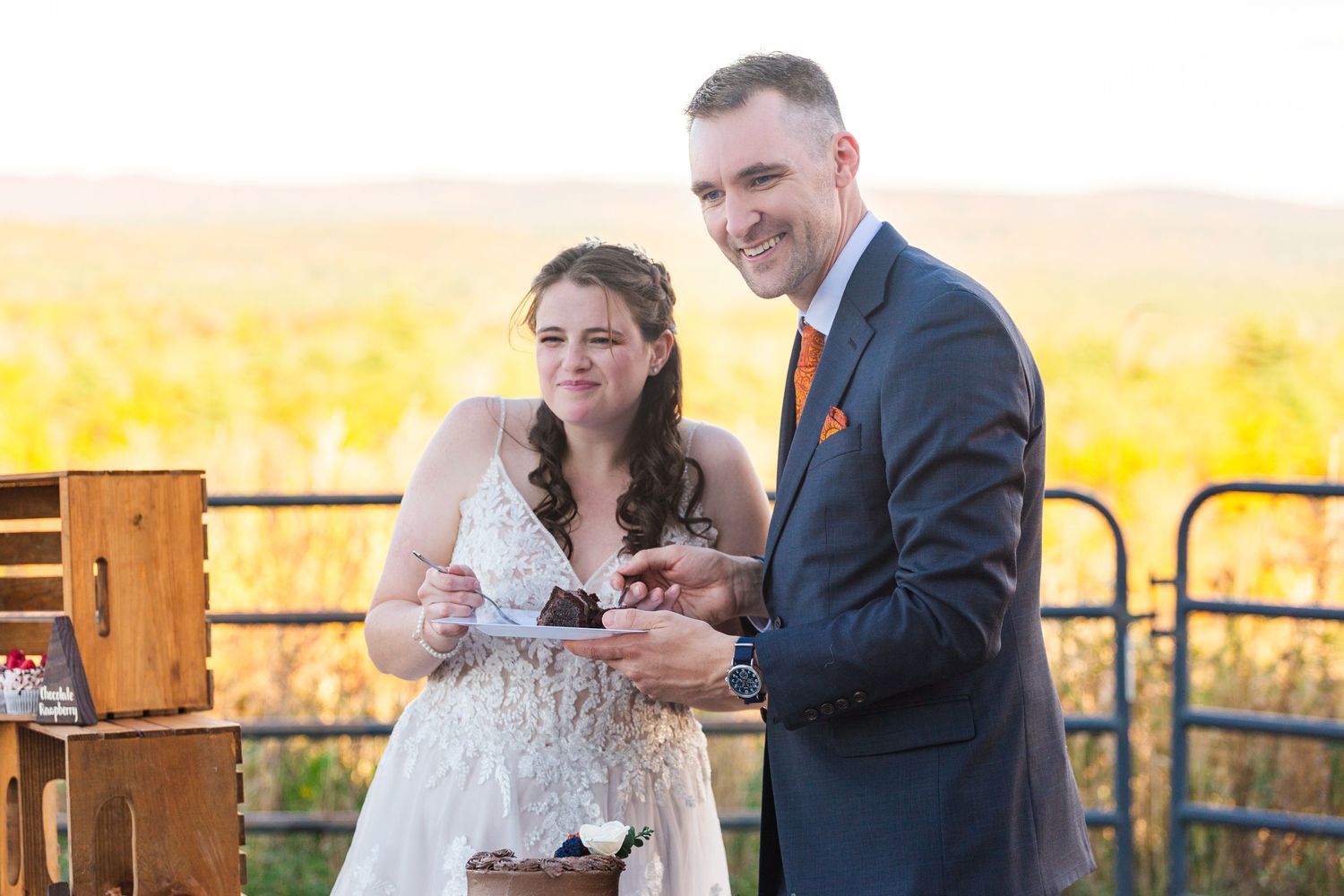 Couple enjoying refreshments at outdoor celebration with scenic mountain view.