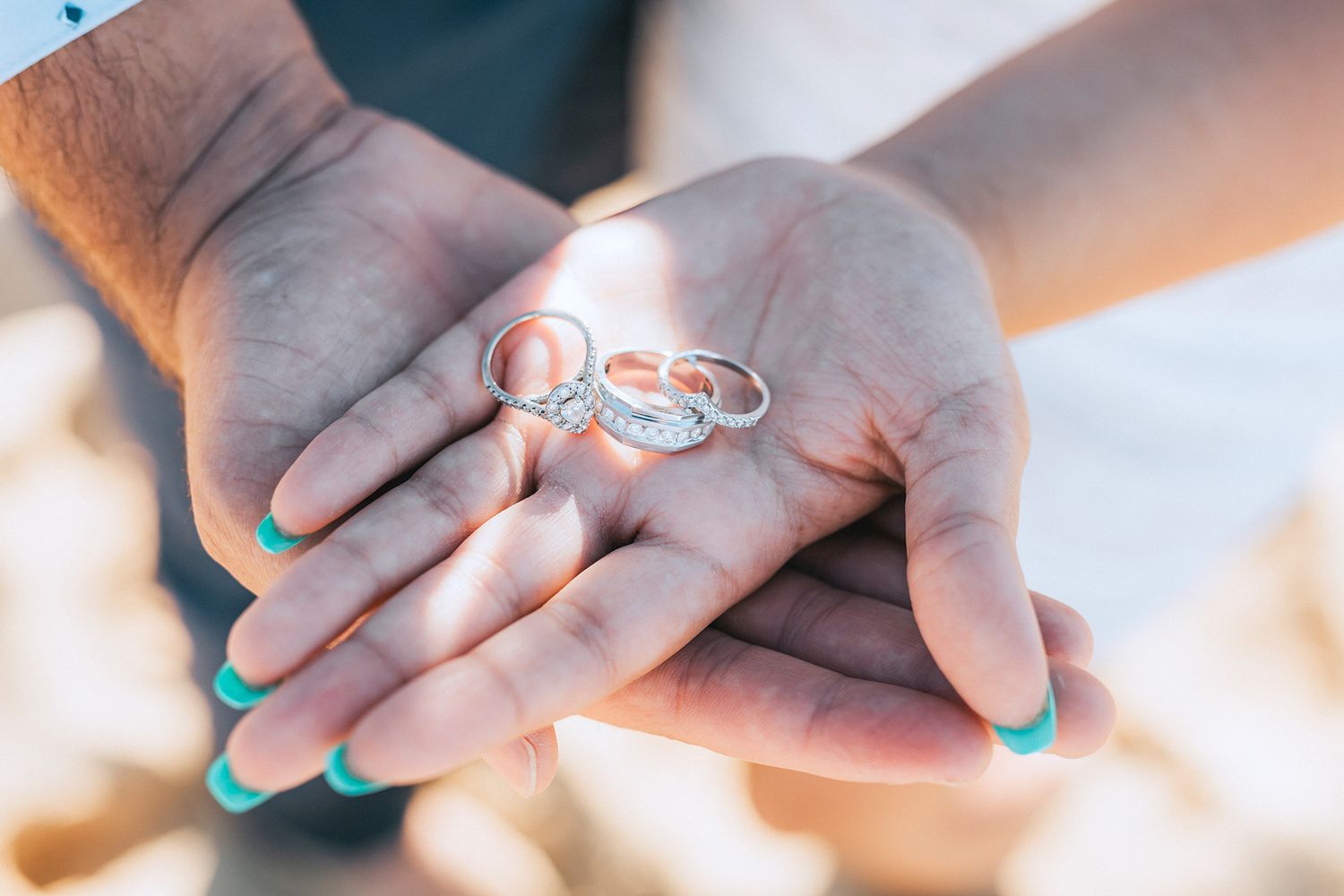 Close-up shots of hands displaying engagement rings with turquoise nail polish.