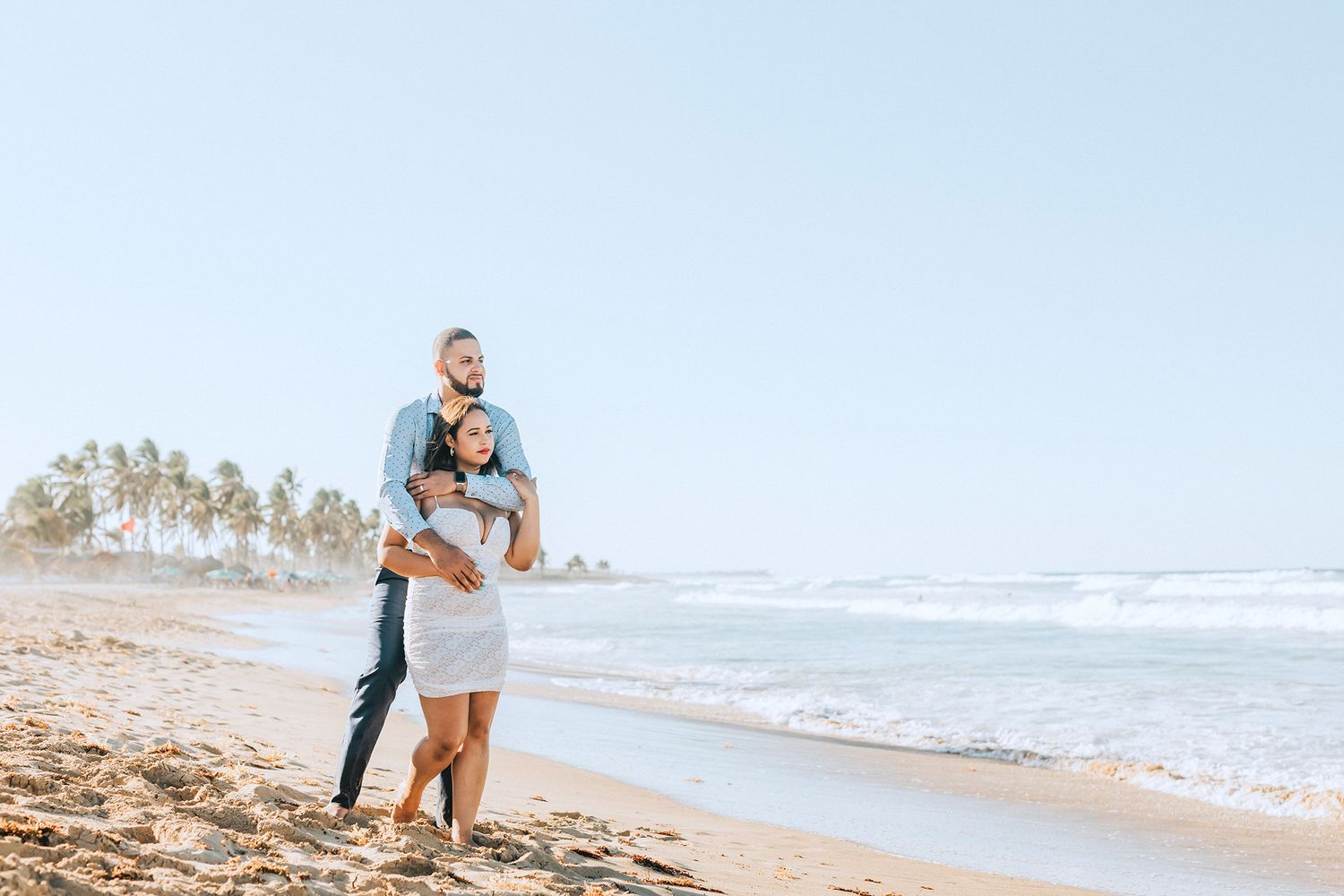 Wide landscape shots of a couple enjoying moments together on a tropical beach.