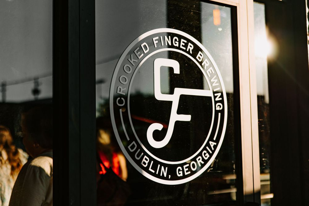 Circular logo design for CF establishment in Dublin, Georgia displayed on dark surface.