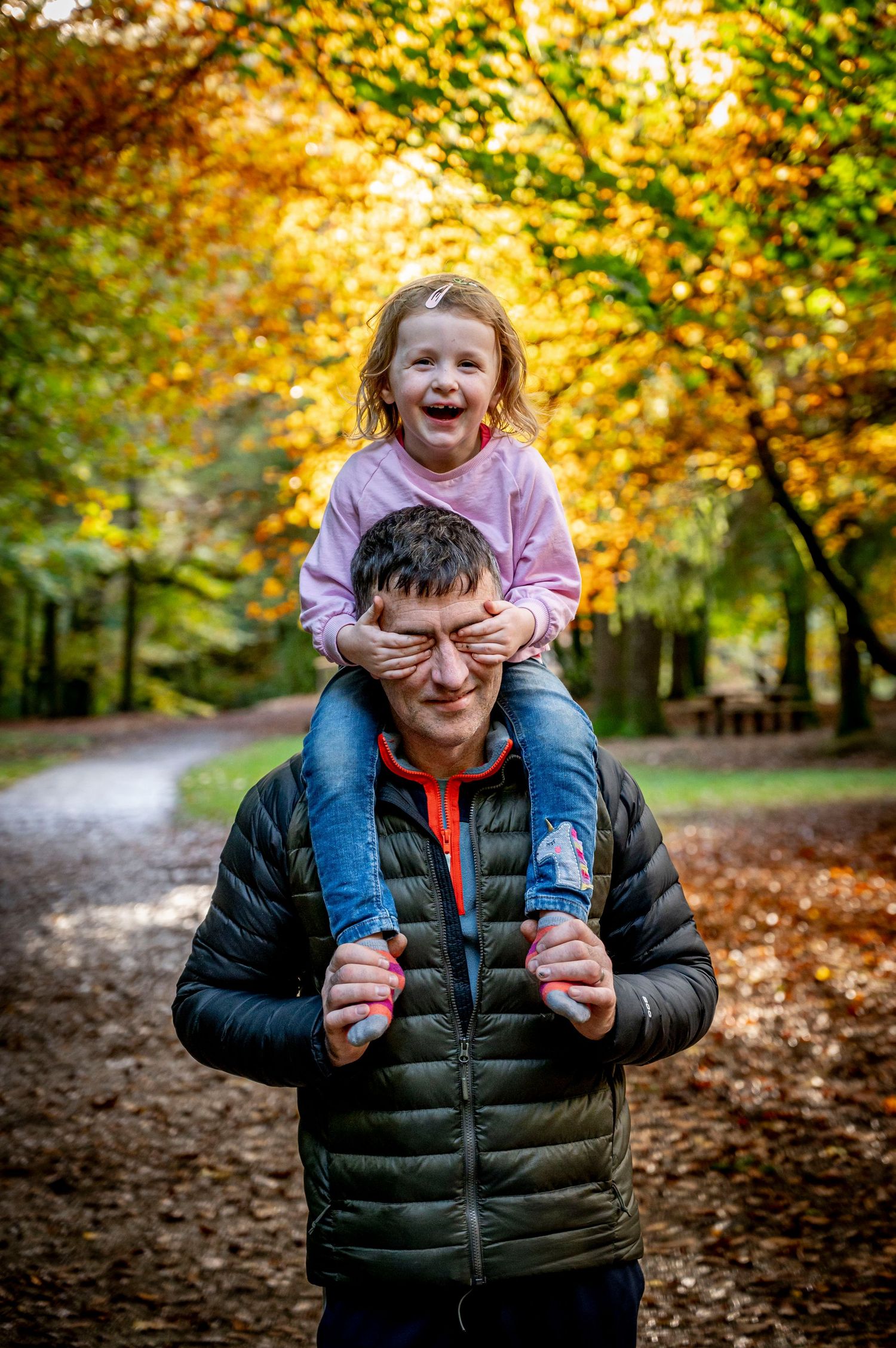 dad and toller on his shoulders in the wood sun breaking through family documentary photography waterford