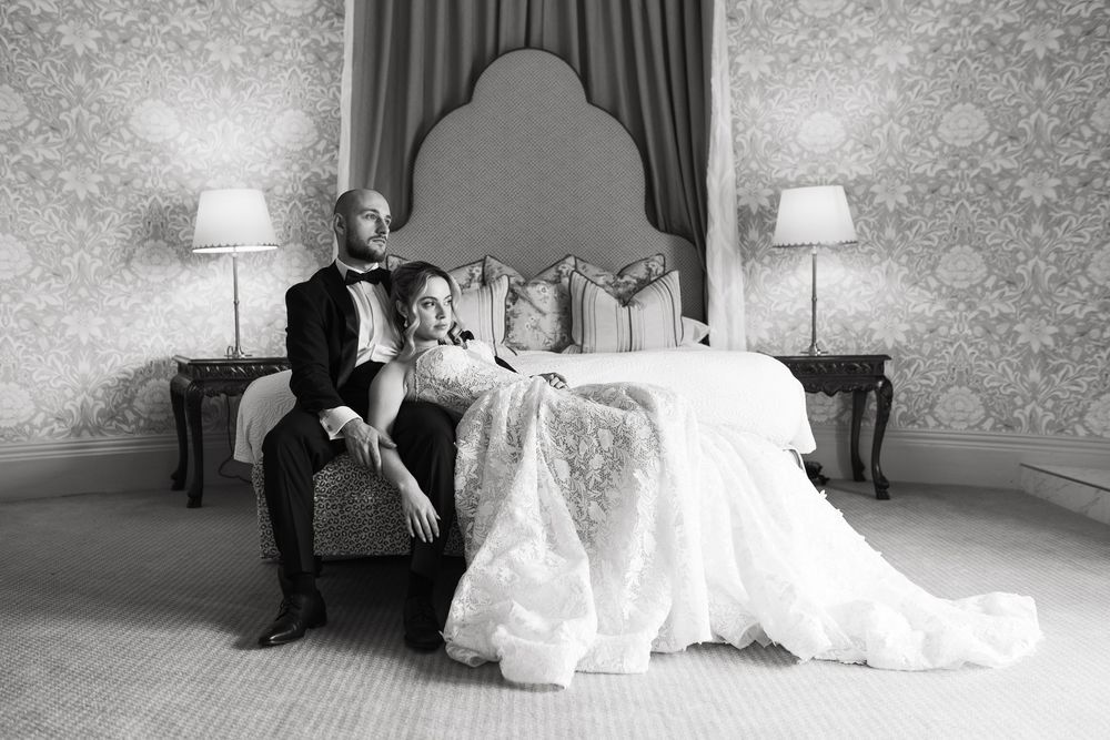 A sequence of black and white images showing a romantic wedding couple reclining and posing on an elegant couch.