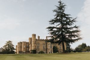 A scenic view of a stone castle with towers and turrets set against green landscaped grounds at Cave Castle - taken by Grimsby photographer.