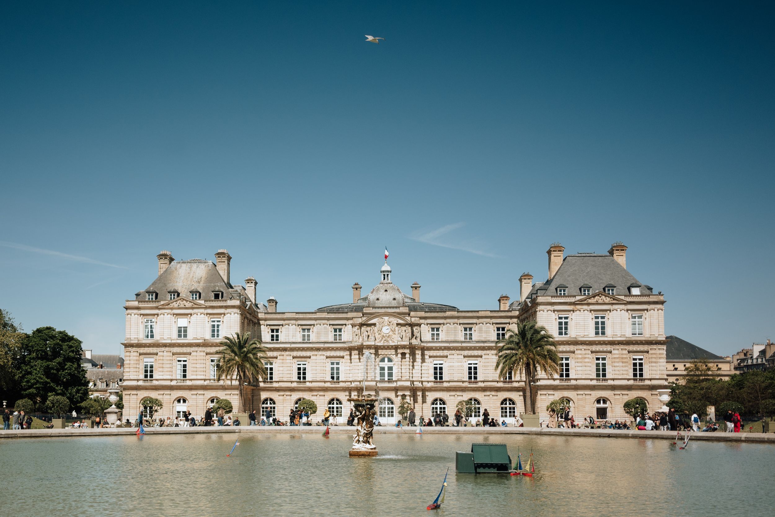Palais du Luxembourg à Paris avec son bassin central et ciel bleu dégagé.