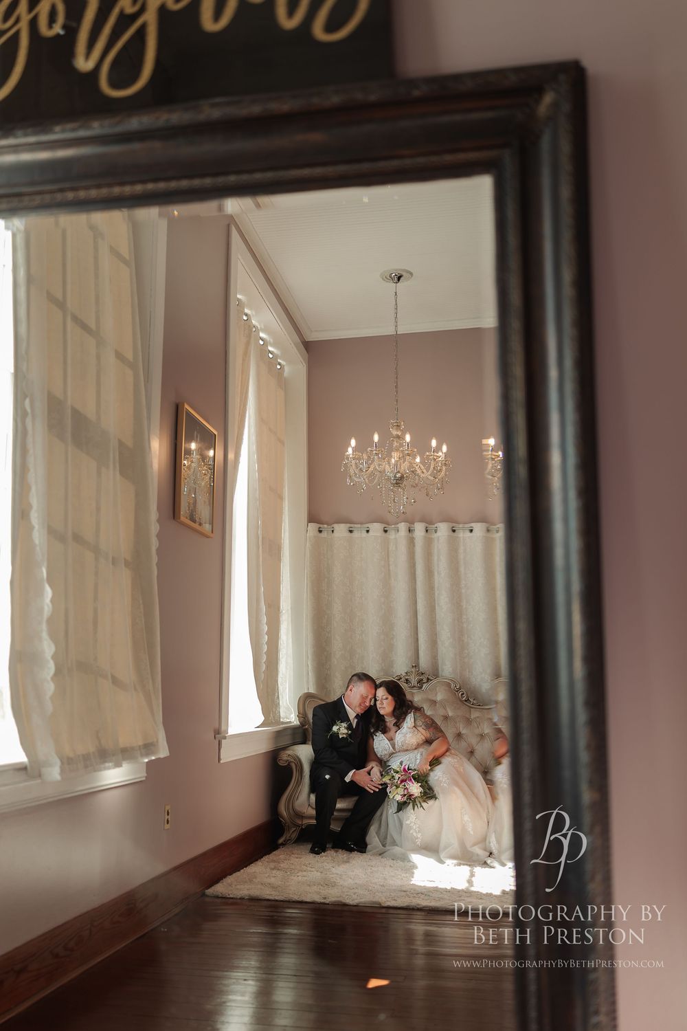 Empty photography studio space with natural light streaming through windows and white curtains.