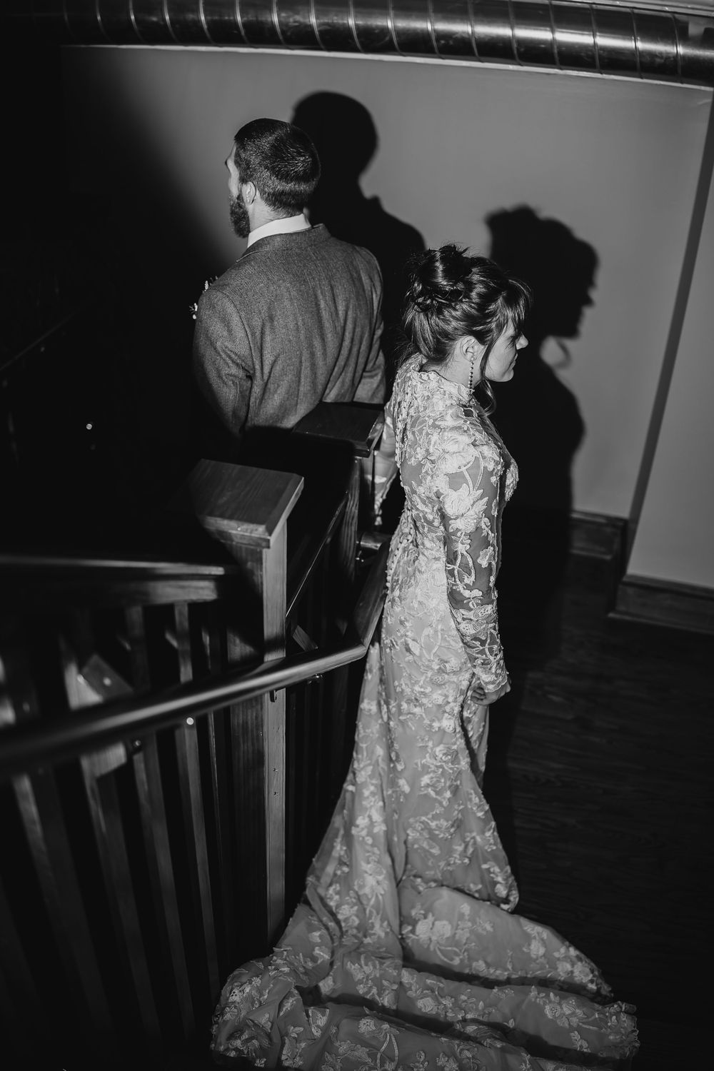 A black and white photo series showing someone in an elegant lace wedding dress walking down church steps.