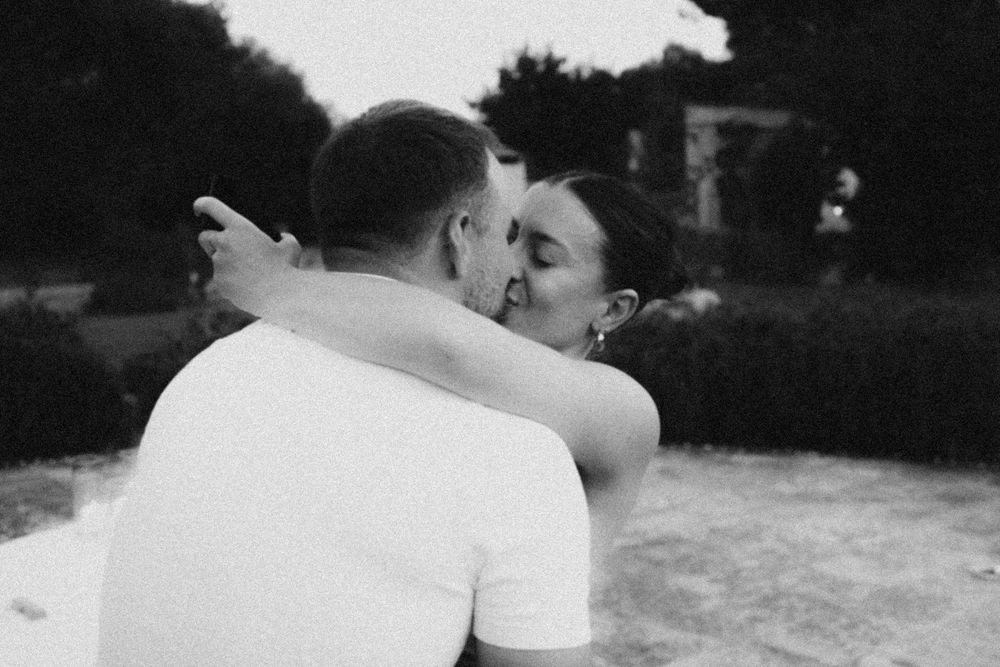 A tender intimate black and white photo of a couple embracing outdoors.