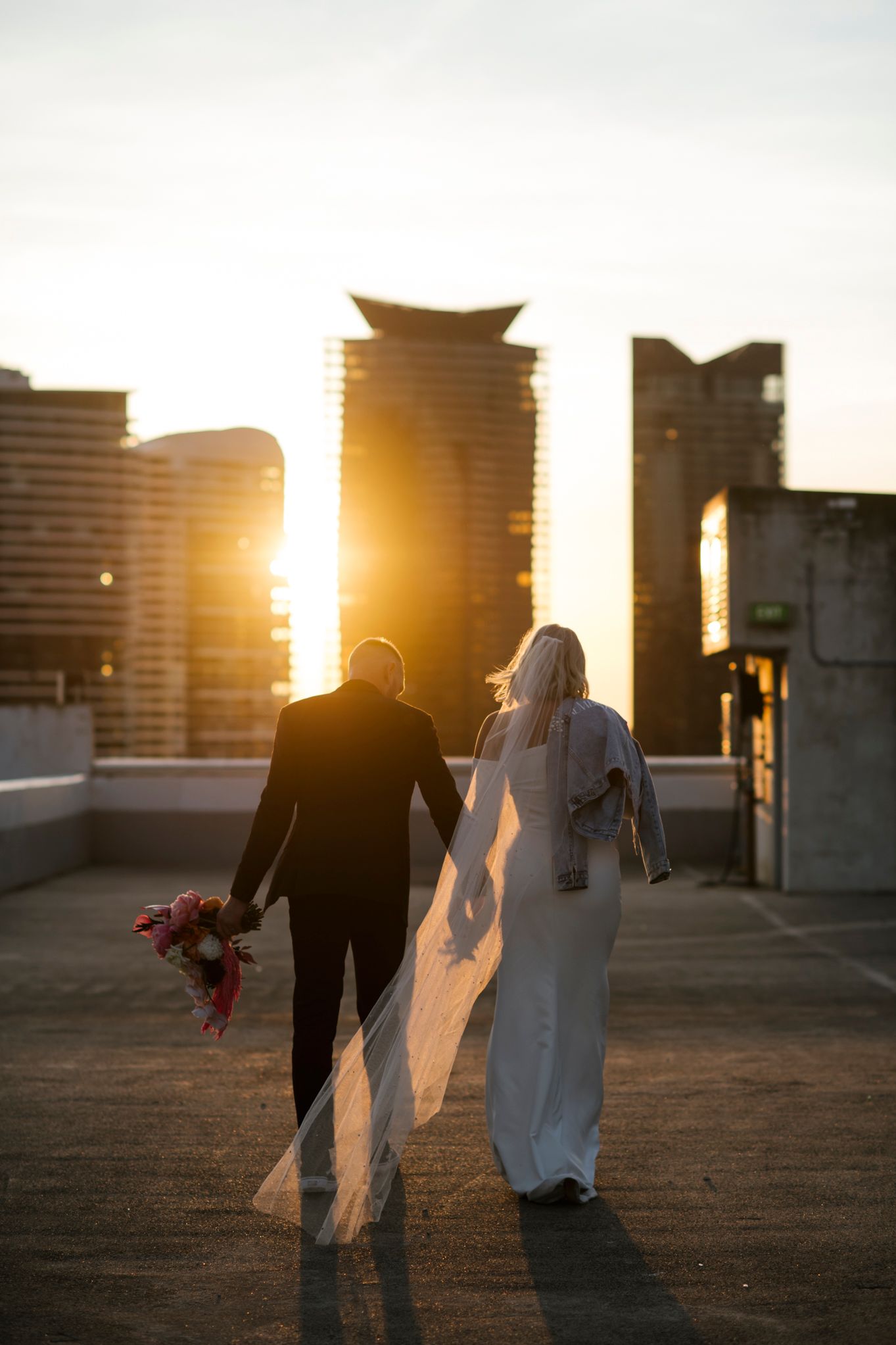 Silhouetted couple against urban skyline during golden hour sunset.