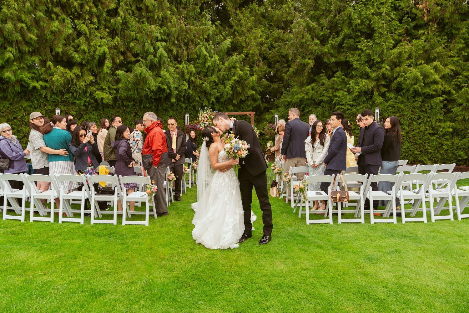 Panoramic view of an elegant wedding reception venue with white tablecloths and large windows letting in natural light.