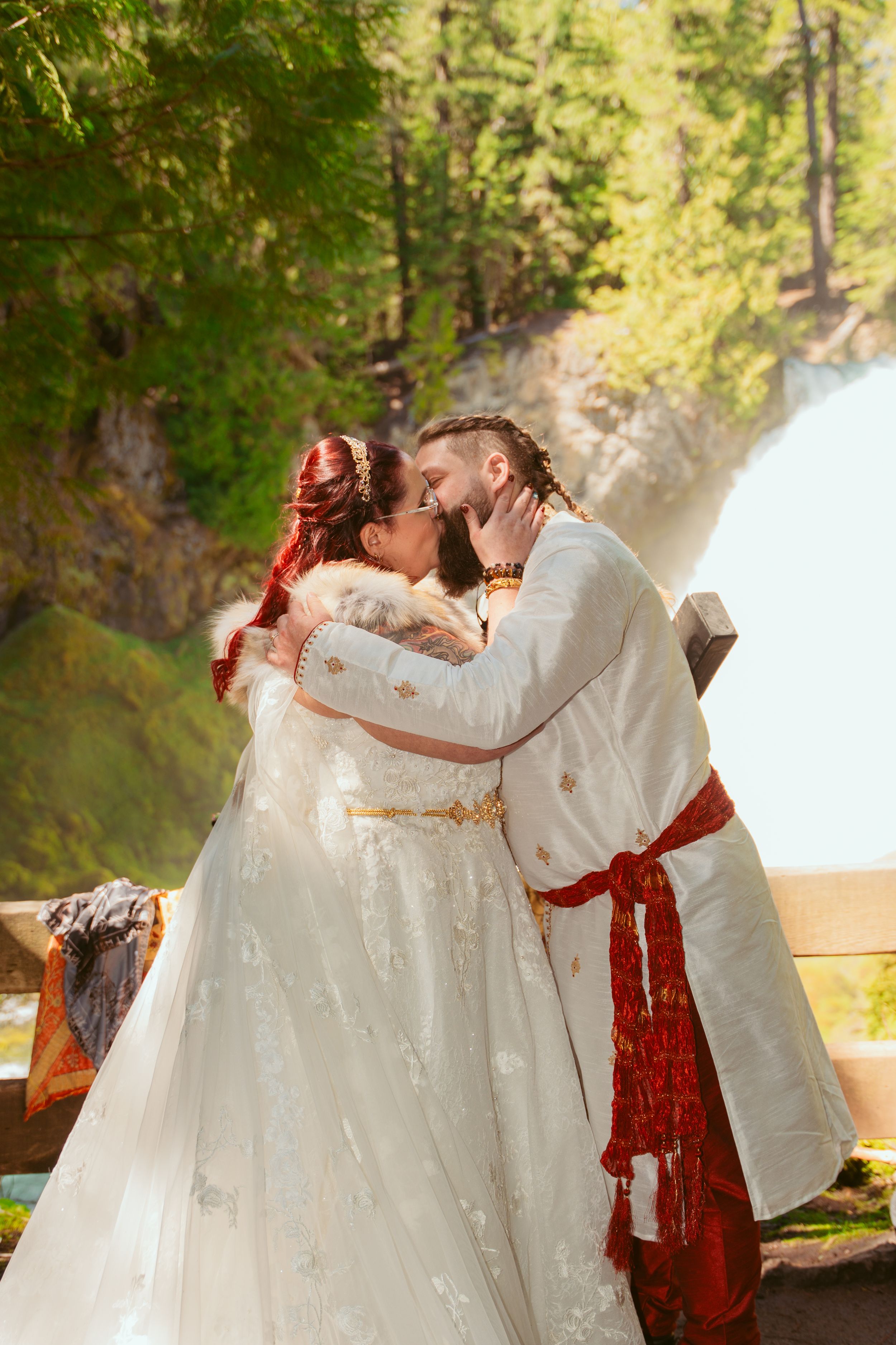 Romantic outdoor wedding photos showing a couple in white embracing near sunlit trees.