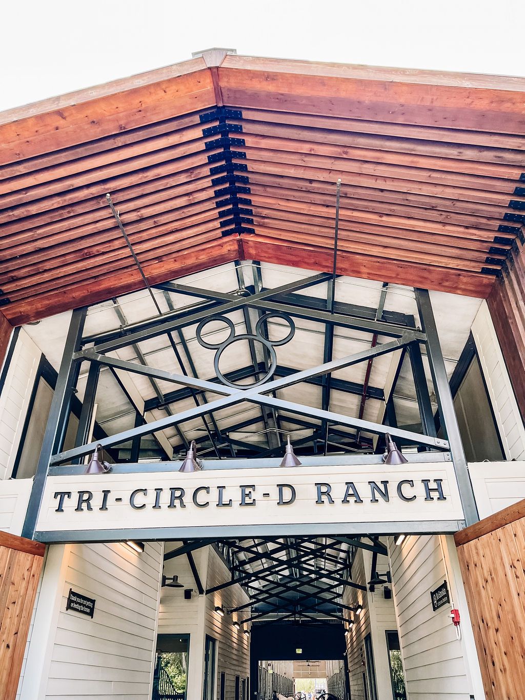 Architectural detail of Tri-Circle-D Ranch entrance sign with wooden beam ceiling.