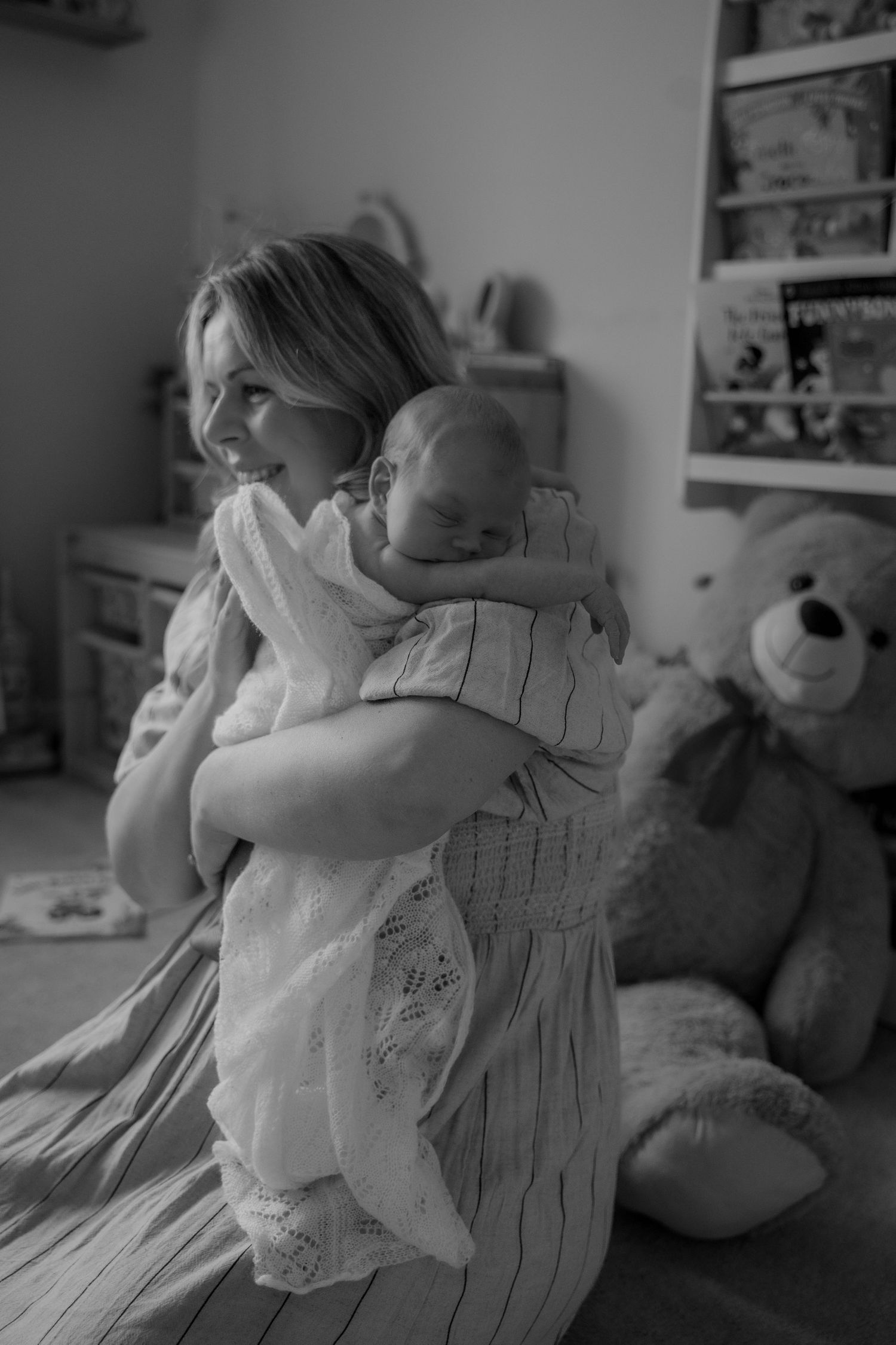 New mum holding her newborn close during a storytelling lifestyle session in Derbyshire.
