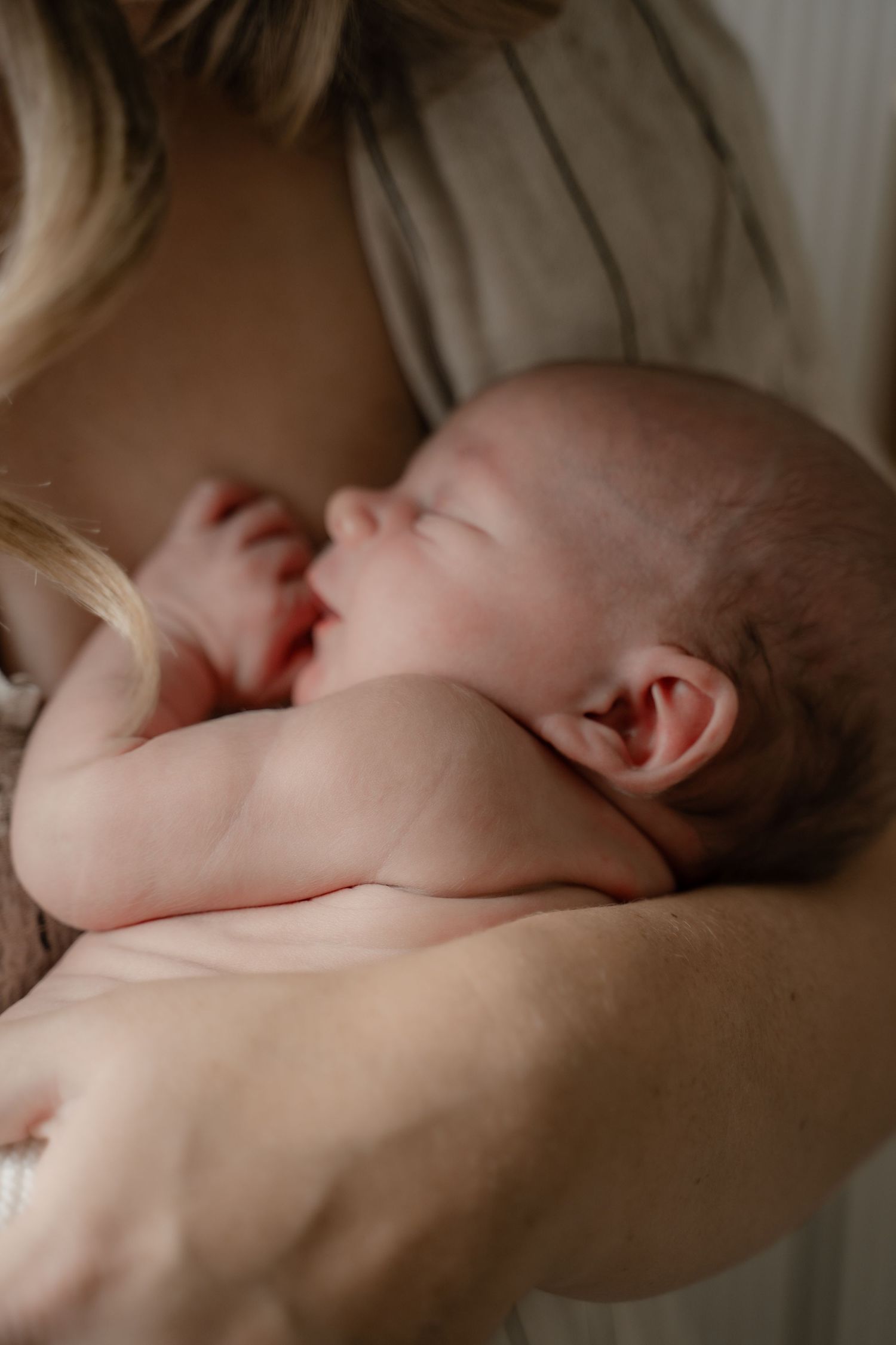 New mum holding her newborn close during a storytelling lifestyle session in Derbyshire.