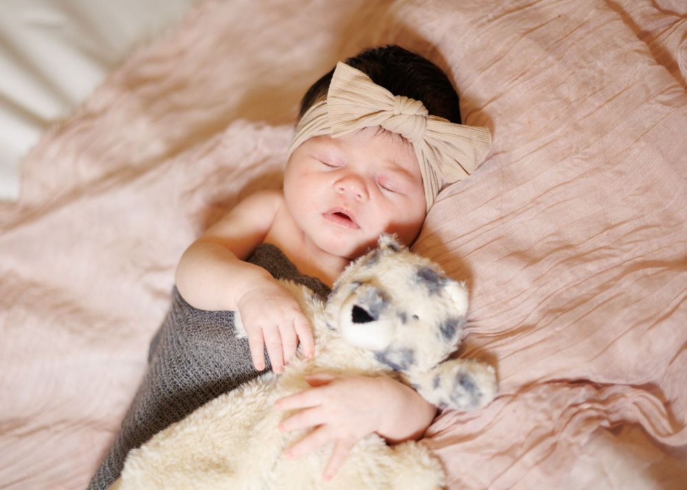 A person lies on a hardwood floor cuddling with a fluffy white dog in a series of heartwarming poses.