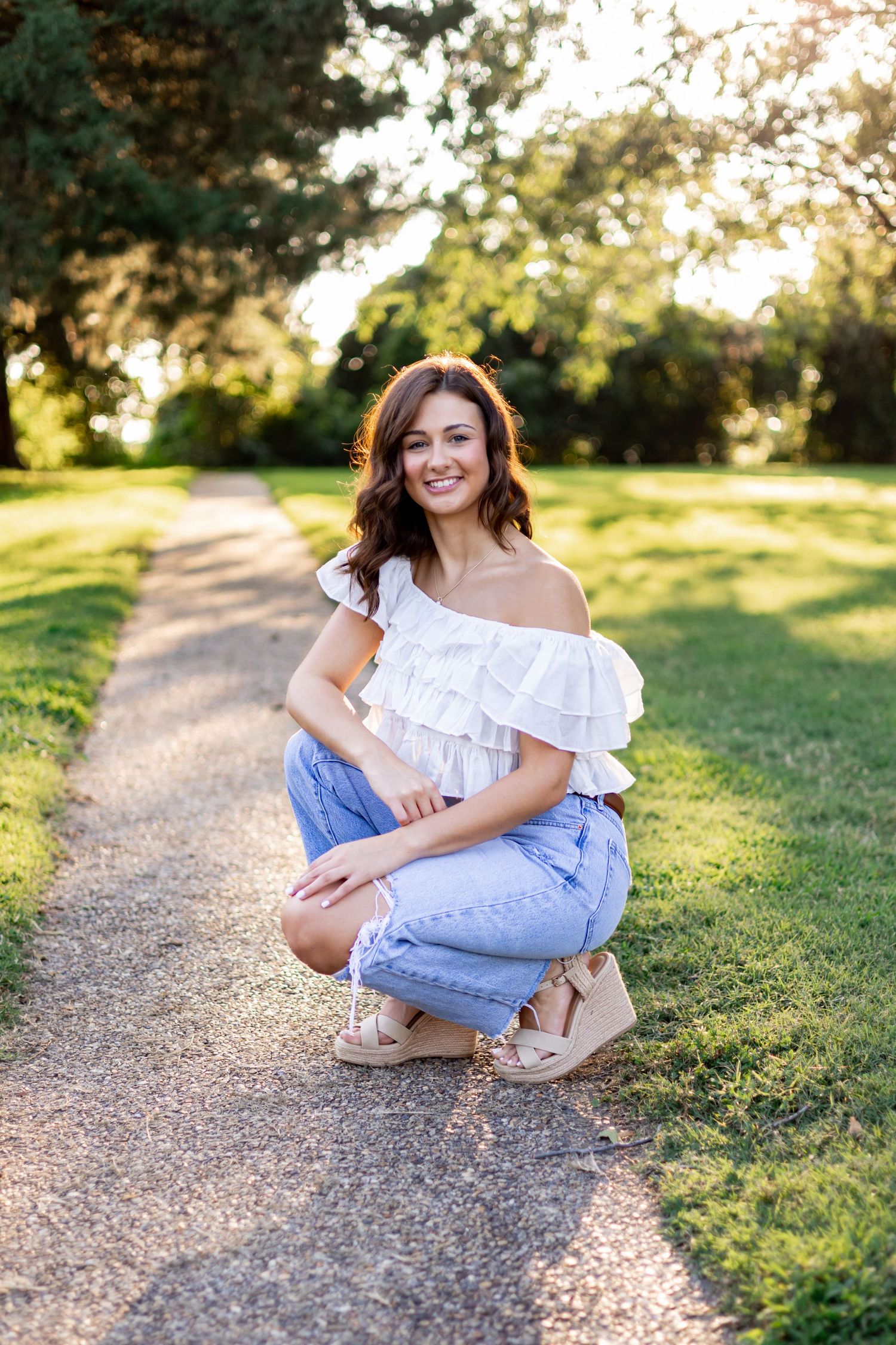 Natural light portraits on gravel path in casual summer attire.