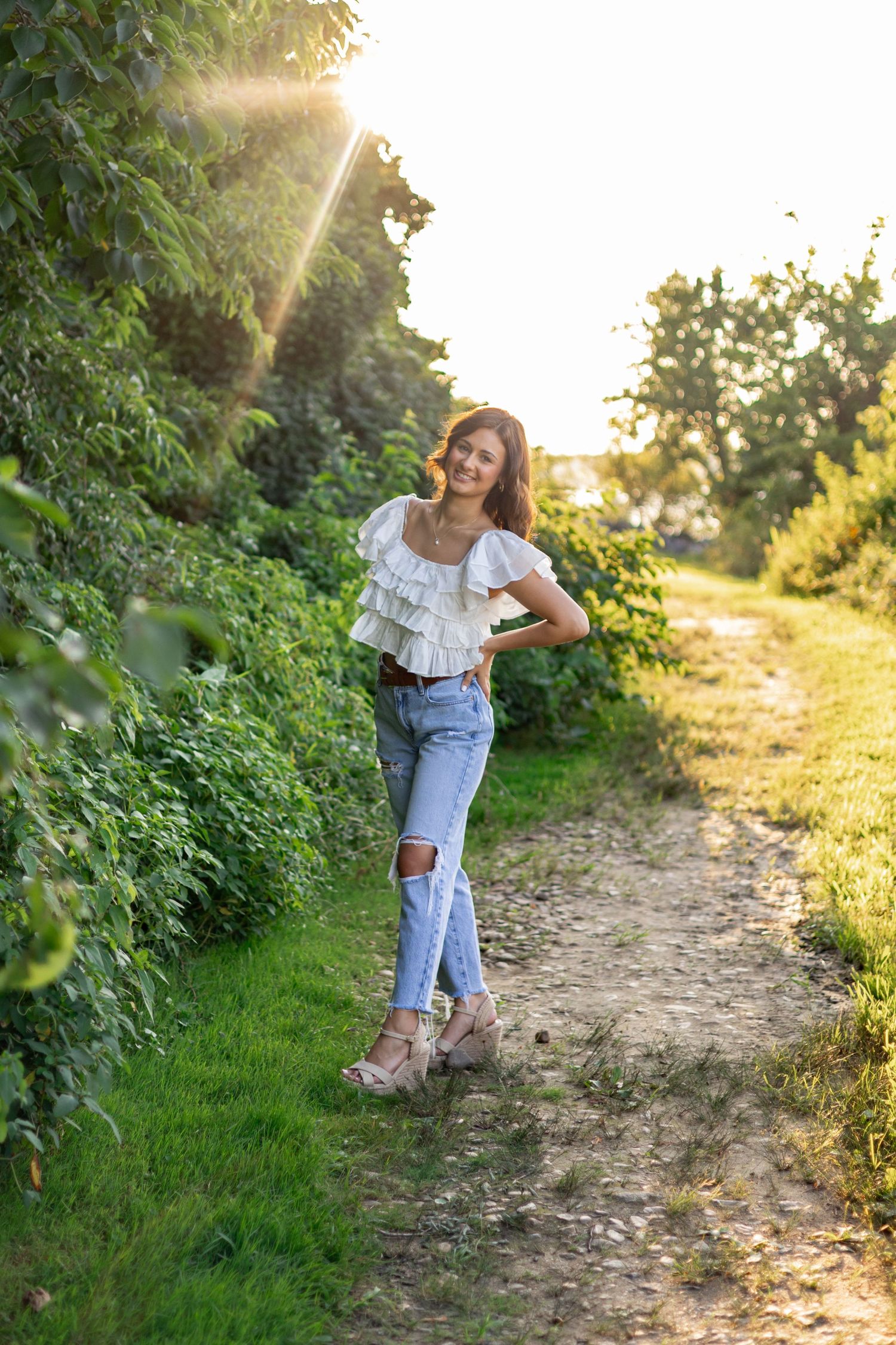 Outdoor fashion series on nature path during sunset in casual summer outfit.