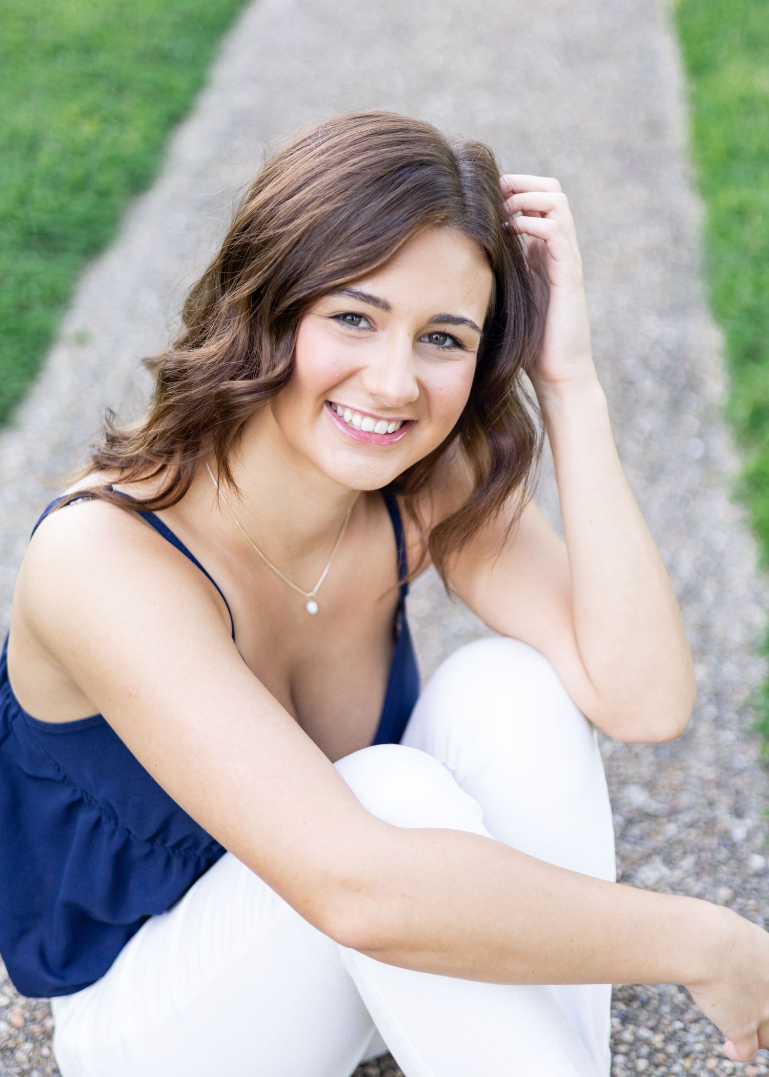 Portrait series in navy and white outfit against outdoor backdrop.