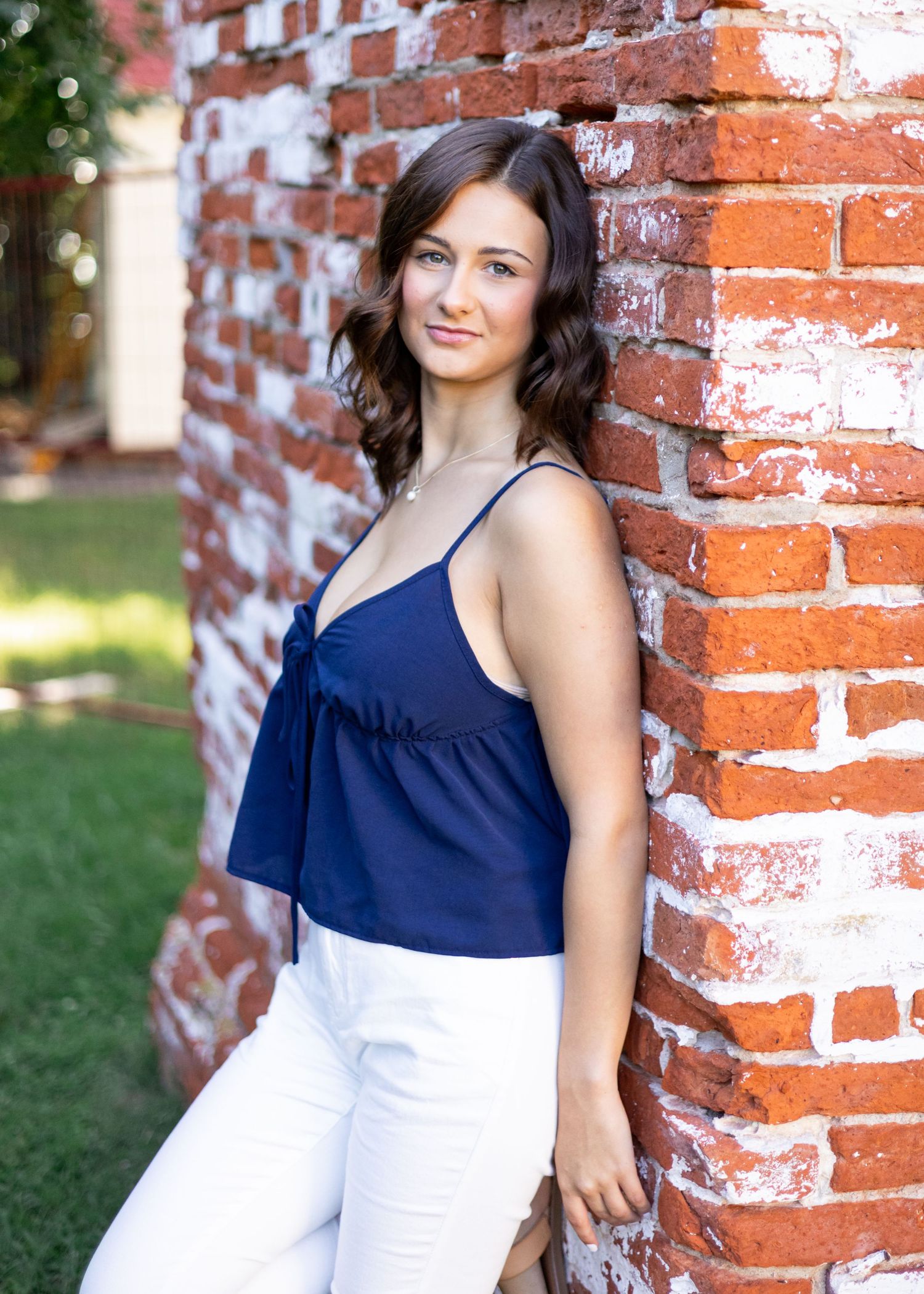 Fashion portraits against rustic brick wall in navy and white ensemble.