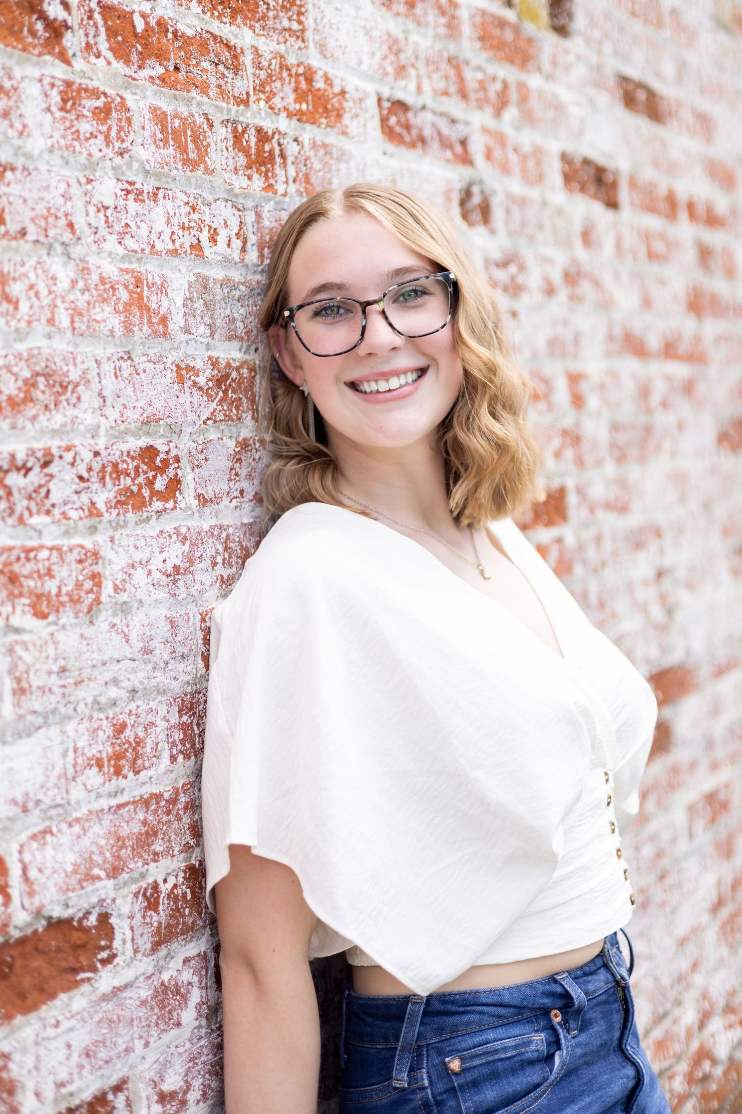 Portrait series against weathered brick wall featuring casual summer style.